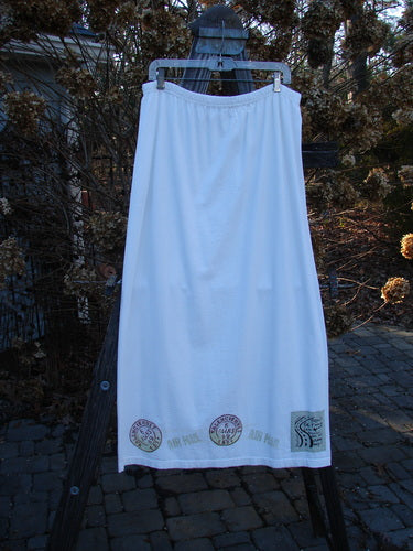 2000 NWT June Straight Duo Postage White Size 2: A white skirt and towel with stamps on a clothes rack.