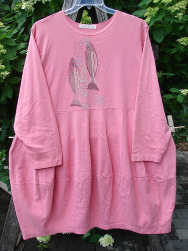 1997 Brenton Dress Two Fish Tulip Size 2, featuring a loose-fitting, long-sleeved pink tunic with stylized fish motifs on the front, subtle hip gathers, and a unique paneled skirt design.