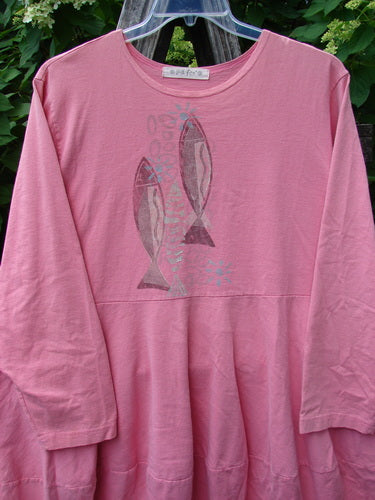 1997 Brenton Dress Two Fish Tulip Size 2 features a long-sleeved pink tunic with stylized fish graphics, a tiered hem, rounded neckline, and deep side pockets, hanging on a clear plastic hanger outdoors.