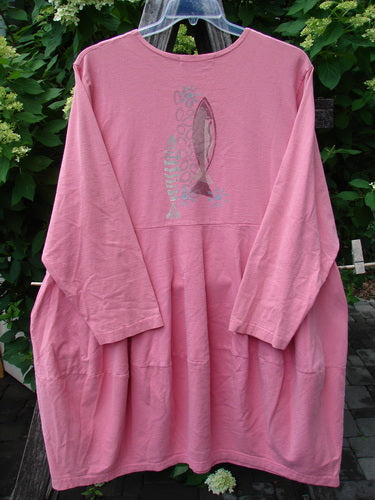 1997 Brenton Dress Two Fish Tulip Size 2, a vintage smock-style top with two fish graphics, gathered flared silhouette, and deep side pockets, hanging against leafy greenery, exemplifying Bluefishfinder.com's unique vintage style.