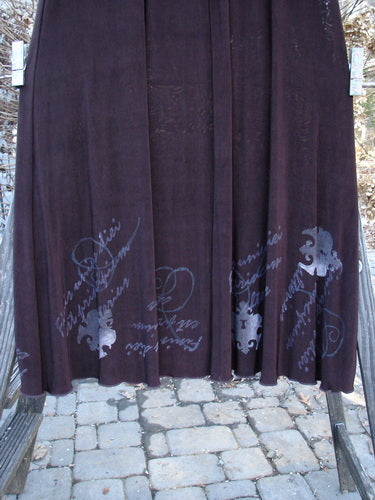 1999 Acetate Streamer Moonbeam Duo Key Deep Burgundy Size 1: A purple blanket on a rack, a long black skirt with writing on it, and a stone walkway.