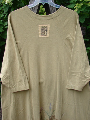 1998 Botanicals Bell Flower Top Iris Pseudacorus Seed Size 2, featuring a loose-fit tunic with three-quarter sleeves, belled A-line shape, subtle floral print, and Blue Fish signature patch, on a plastic hanger.