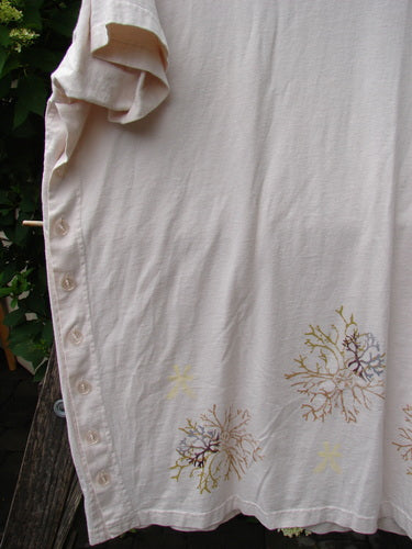 The 1997 Mauritius Top Sea Coral Powder OSFA features light-cream organic cotton, side buttons, and coral-like motifs. It showcases unique design elements like tall side vents and a bell shape.