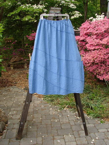 A Barclay Linen Diagonal Skirt in Skylark, Size 2, with exterior diagonal stitchery. Slightly shorter and boxier length. Unpainted on the diagonal. Perfect for building a special look. Full cotton waist relaxed 32, waist extended 42, hips 60. Length is 38 inches.