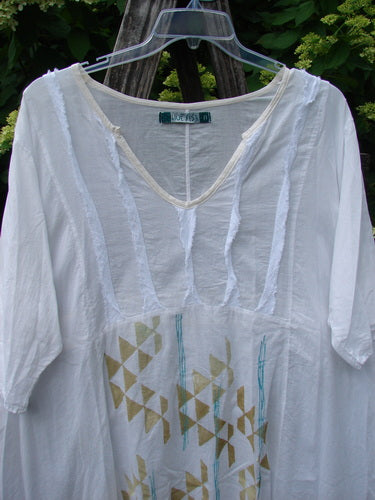 Barclay Batiste Flutter Bib Tie Back Dress features a V-neck and three-quarter sleeves with a geometric gold triangle print, reflecting Bluefishfinder.com's vintage style. Perfect for expressing individuality.