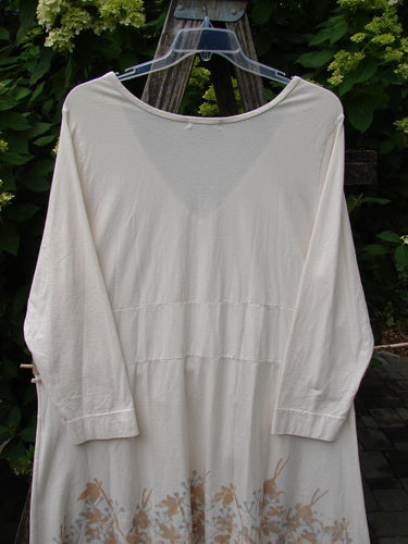 Barclay Deep V Neck Rear Banded Pocket Tunic Morning Garden Dew Size 1, featuring a loose-cut design with subtle floral patterns on the lower portion, elegantly displayed outdoors against lush foliage.