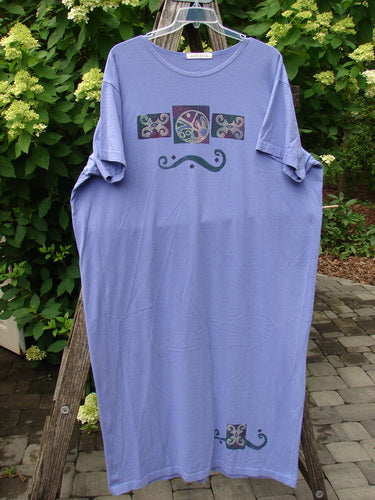 1997 Aquavella Dress Celtic Trio Skylark Size 2 features a loose lavender design with stylized swirl graphics on chest and hem, displayed on a hanger against an outdoor backdrop.