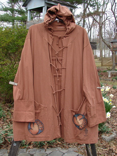 Vintage brown hooded jacket coat with laces and floral detail, reminiscent of creative freedom in fashion.