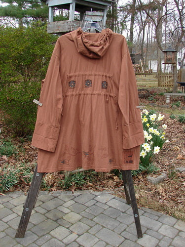 Vintage Albion Hooded Jacket Coat on rack, stone walkway, flower close-up.