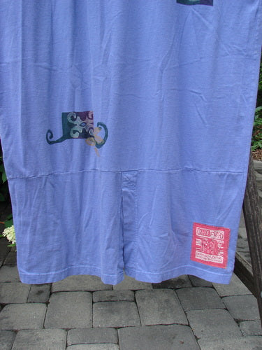 1997 Aquavella Dress Celtic Trio Skylark Size 2 draped over a wooden bench, showcasing its scooped neckline, drop shoulders, and tapered hem with subtle cat-whisker prints and a red label near the hem.