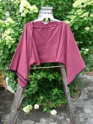 Barclay Cotton Lycra Contrast Crop Shrug Deep Celtic Curl Wine Size 2 displayed on a wooden ladder, showcasing its super crop wide shape, belled lowers, and laced neckline amid lush greenery.