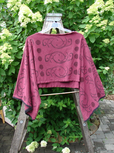Barclay Cotton Lycra Contrast Crop Shrug Deep Celtic Curl Wine Size 2, displayed on a wooden ladder, features a swirly black print, belled sleeves, and a laced neckline, showcasing its creative design.