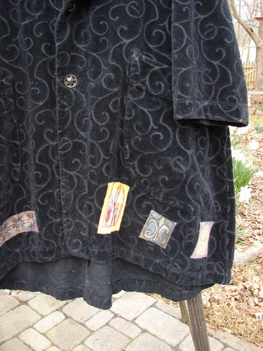 Black coat with a pattern, close-up of sleeve and textile details, size 0.
