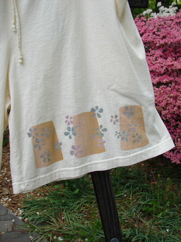 2000 NWT The Summer Short Tiny Daisy Milk Size 2: A white shirt with a flower design on it, featuring a close-up of a flower and grass.