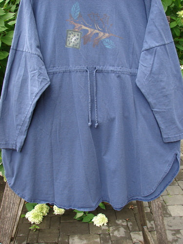 The 1996 Long Sleeved Pop Top Fall Leaves Niagara OSFA features a muted blue tunic with a drawstring waist, decorative chest graphic, and oversized pocket, draped over a chair with foliage backdrop.