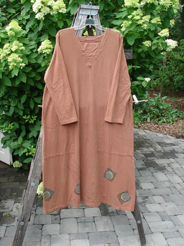 1998 Mandolin Dress Lucky Horseshoe Rockwood Size 2, loose-fitting with long sleeves, shallow V-neck, and unique front pockets, hangs on a wooden ladder against a shrubbery backdrop, reflecting vintage Blue Fish creativity.