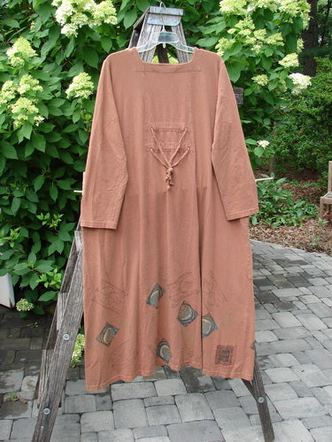 1998 Mandolin Dress Lucky Horseshoe Rockwood Size 2, featuring a loose fit, full-length sleeves, triangular pocket ties, and unique patchwork near hem, displayed on a wooden ladder outdoors.