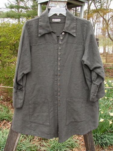 Barclay Linen Metal Button Drop Pocket Pullover Unpainted Grey Storm Altered Size 2 displayed on a clothes rack, showcasing its unique button accents, offset V-shaped neckline, and double drop front pockets.