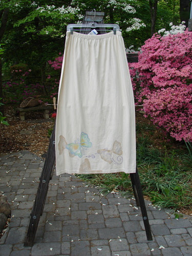 1999 NWT Straight Skirt Butterfly Natural Size 2: A white skirt adorned with butterfly-themed paint all around the hem. Made from organic cotton, this straight skirt features a full elastic waistband and a straighter shape. Perfect condition. Length: 40 inches.