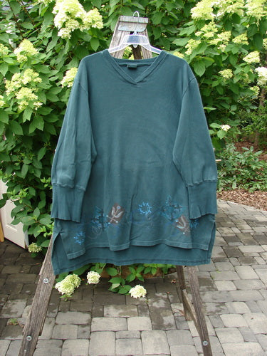 Barclay Interlock V Neck Vented Tunic Top Celtic Tumble Forest Teal Size 2, featuring a heavy ribbed neckline, shirttail hem, and subtle motif along the hem, displayed on an outdoor ladder.