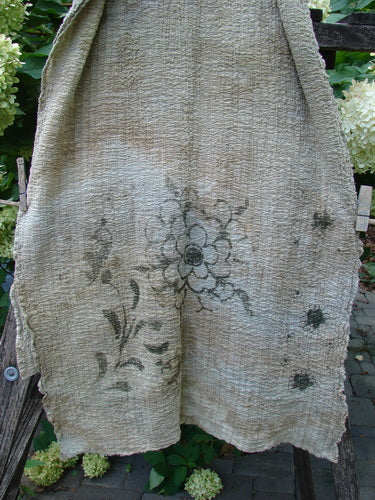 Barclay Crinkle Cotton Scarf Morning Fern Mottled Wheat OSFA draped on a rustic ladder, featuring hand-drawn black floral motifs, highlighting its cozy texture and organic cotton elegance.