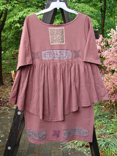 1993 Picnic Dress featuring a fern and flower theme, in boysenberry color. One size fits all. Made from mid-weight cotton. Gently rounded V-shaped neckline, flirty continuous flounce, and vintage signature patch. Bust 44, waist 46, hips 46, length 38 inches.