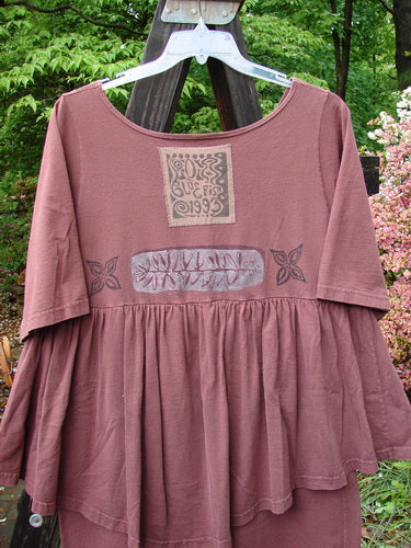 1993 Picnic Dress with fern and flower theme paint and vintage signature patch, in boysenberry color. Gently rounded V neckline, flirty continuous flounce, and straight upper waist seam. Bust 44, waist 46, hips 46, length 38 inches.