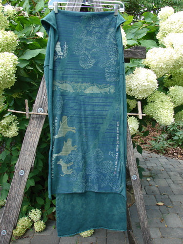 Barclay Wide Sectional Scarf Wrap Forest Animals Mottled Green OSFA, draped over a ladder, features enchanting forest animal motifs, painted stripes, and curly edges, exemplifying BlueFishFinder’s creative, vintage-inspired style.