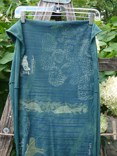 Barclay Wide Sectional Scarf Wrap Forest Animals Mottled Green OSFA, draped on a wooden frame, features woodland motifs and curly edges, ideal as a shawl or scarf.