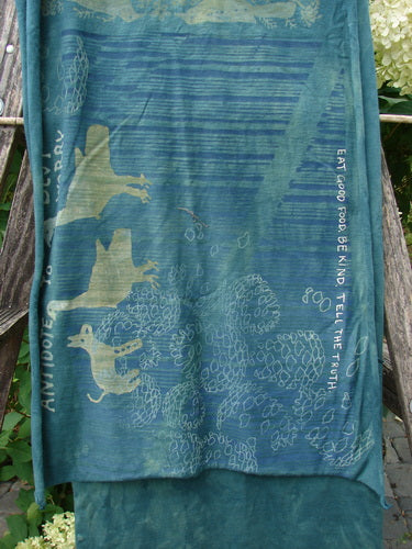 Barclay Wide Sectional Scarf Wrap Forest Animals Mottled Green OSFA draped over a wooden rail, displaying birds and berries print, curly edges, and motivational quote. Hydrangea blooms visible in the background.