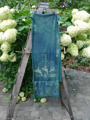 Barclay Wide Sectional Scarf Wrap Forest Animals Mottled Green OSFA drapes over an A-frame, featuring enchanting motifs and motivational quotes, capturing Bluefishfinder.com's creative spirit on a stone-paved patio.
