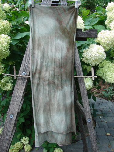 Barclay Diagonal Sectional Scarf Wrap in Unpainted Mottled Night Storm OSFA draped over a wooden ladder, showcasing its medium-weight organic cotton fabric with sweet finished curly edges and diagonal sectional seams.