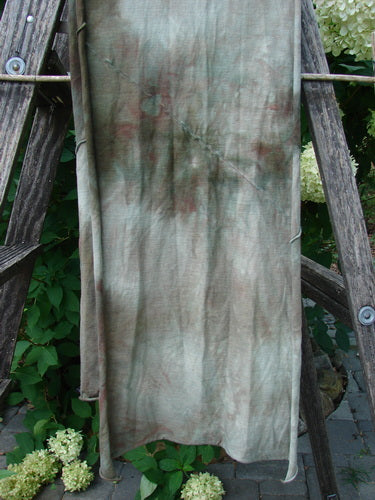 Barclay Diagonal Sectional Scarf Wrap Unpainted Mottled Night Storm OSFA draped over a wooden ladder, showcasing its medium-weight organic cotton and sweet curly edges amidst greenery and flowers.