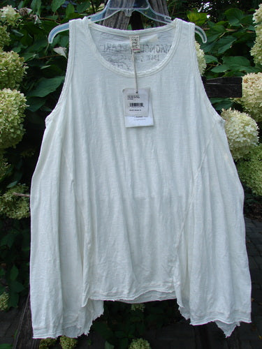 Magnolia Pearl NWT Cotton Paz Tank White OSFA displayed outdoors, featuring featherweight cotton texture, raw edges, and a unique A-line flare. The tank has hand-distressed details and a signature logo stamp on the back.