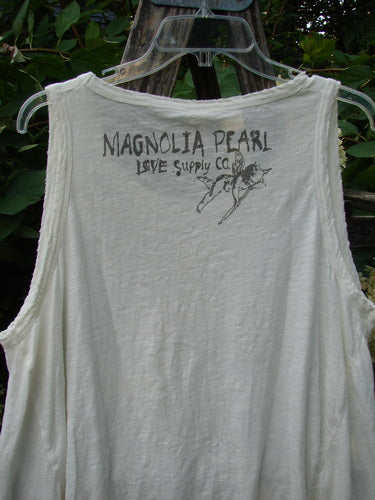 Magnolia Pearl NWT Cotton Paz Tank White OSFA displayed on a hanger, featuring hand-distressed edges and a signature winged pig graphic near the neckline, epitomizing vintage-inspired, creatively expressive fashion.