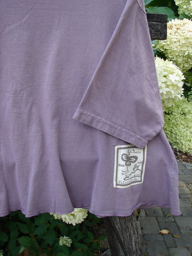 Barclay PMU Patched Short Sleeved Crop A Line Tee in Dark Mallow, displayed over a wooden backrest, features a unique front alligator-themed patch and signature patch, epitomizing Bluefishfinder.com's upcycled vintage style.