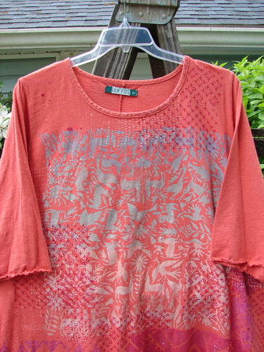 Image alt text: Barclay Three Quarter Sleeved Textured A Lined Tee Top - A red shirt with a pattern on it, featuring a super graduating A lined shape, rounded and flattened neckline, little curly edgings, and festive forest theme paint. Made from mid-weight slightly textured organic cotton. Size 2.