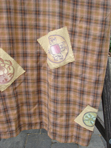 1999 Patched Overall Jumper Mixed Far Eastern Gold Plaid Size 2, featuring brown-and-orange plaid fabric with cream appliqué patches: circular motif, green floral, and red sunburst designs, displayed outdoors.