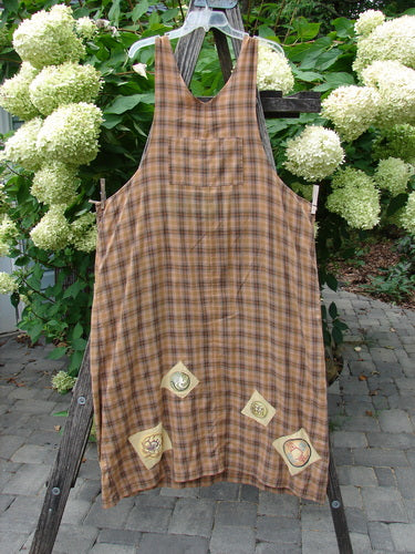 1999 Patched Overall Jumper Mixed Far Eastern Gold Plaid Size 2 displayed on a wooden stand, showcasing its plaid pattern and decorative appliqué patches along the hem, emphasizing its unique vintage style.
