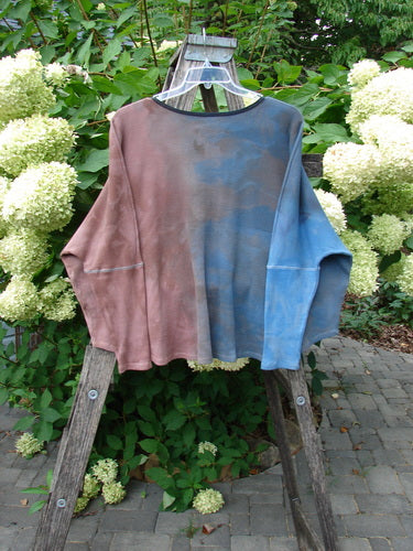 Barclay NWT Thermal Crop Top in Mottled Bibbi Blue hangs on a ladder, showcasing its A-line flair, cropped length, and drop shoulders, highlighting the creative design ethos of Bluefishfinder.com.