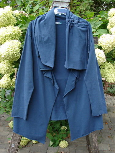 Barclay Cotton Lycra Gather Collar Open Front Jacket in Navy, elegantly draped on a wooden ladder outdoors, showcasing its unique neckline and flowing design amidst hydrangea blooms and lush foliage.