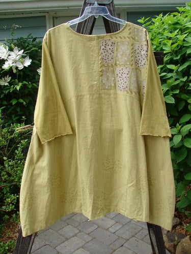 A Barclay Cotton Sleeve Hemp Linen Sectional Dress in Mustard, size 2. A yellow dress on a clothes rack, featuring a sectional upper, pleated A-line shape, and contrasting cotton three-quarter length sleeves. Perfect for a spring collection.