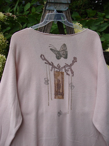 1994 2 Button Cardigan Sweater Magical Garden Pink Granite OSFA displayed on a hanger outdoors, showcasing a butterfly and tree branch motif on the back, highlighting its oversized, textured cotton knit design.