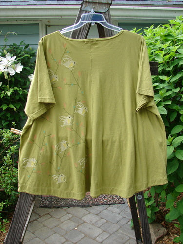 A Barclay Double Pocket Twinkle Top in Peapod, featuring a songbird design on a green shirt.