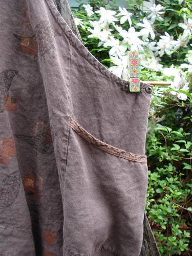 Barclay Linen Adjustable Snap Apron Jumper Playful Chirp Mocha Size 2 features adjustable metal snaps, a pocketed upper bib, dual side wrap pockets, and a varying hemline with a playful birdie theme.
