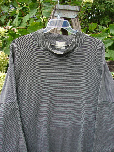 1999 Cotton Lycra Square Mock Pullover Unpainted Black Stripe Size 2 displayed outdoors, showcasing its oversized boxy shape, dolman drop shoulders, and stand-up mock turtleneck against a lush green foliage backdrop.
