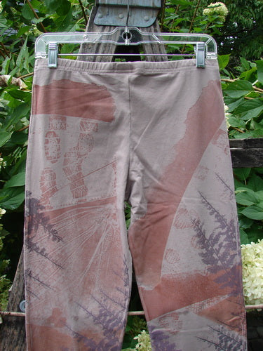 Barclay NWT Cotton Lycra Side Gather Drawcord Legging Forest Moon Oriel Size 1, featuring abstract rusty red and purple patterns with side drawcords, displayed hanging outdoors on a plastic hanger.