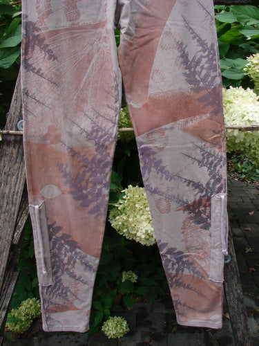 Barclay NWT Cotton Lycra Side Gather Drawcord Legging Forest Moon Oriel Size 1 draped over a garden bench, featuring muted earth-tone fern prints, showcasing a relaxed fit with exterior drawcords.