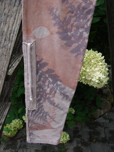 Barclay NWT Cotton Lycra Side Gather Drawcord Legging Forest Moon Oriel Size 1 draped over a rustic ladder, showcasing its unique fern and abstract print, complemented by a white hydrangea bloom.