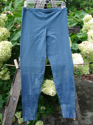Barclay NWT Cotton Lycra Legging Light Scribe Echo Blue Size 1, displayed on a hanger amidst shrubs and hydrangeas, features a full elastic waistband, tapering lowers, and a soft, forgiving feel.
